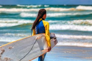Girl on beach with surfboard